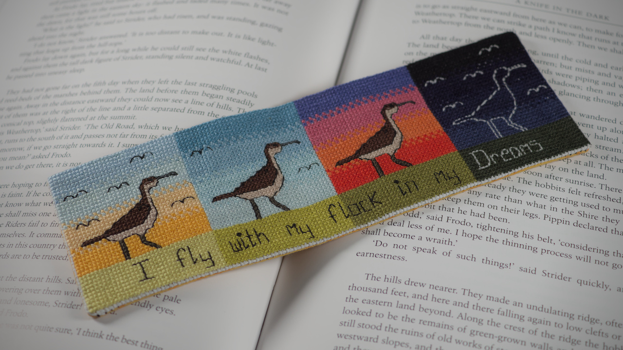 An image of a bookmark depicting four birds in the foreground across different times of day. It reads 'I fly with my flock in my dreams'